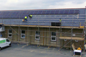 Engineers installing solar panels on the roof of Clunderwen Hall, Pembrokeshire