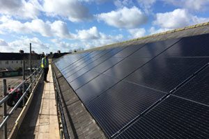 Photovoltaic solar panels being installed on the roof of Maesglas Primary & Nursery School, in Newport, Gwent.